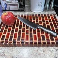 Handcrafted multi-wood brick pattern cutting board — custom kitchen woodwork by Two Mittens